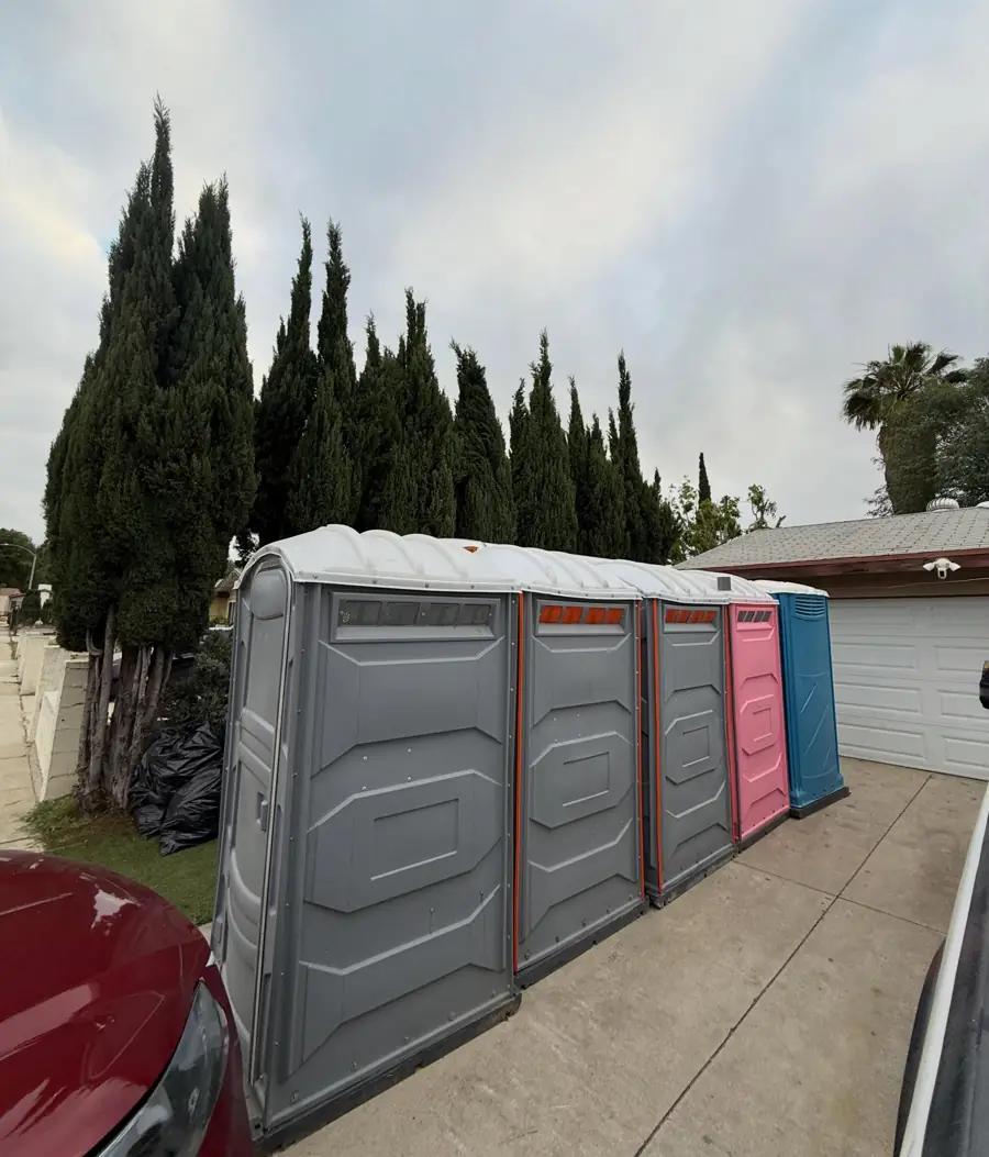 Row of portable toilets on a concrete driveway